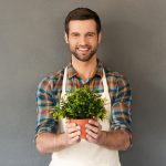A man holding a plant in his hands.